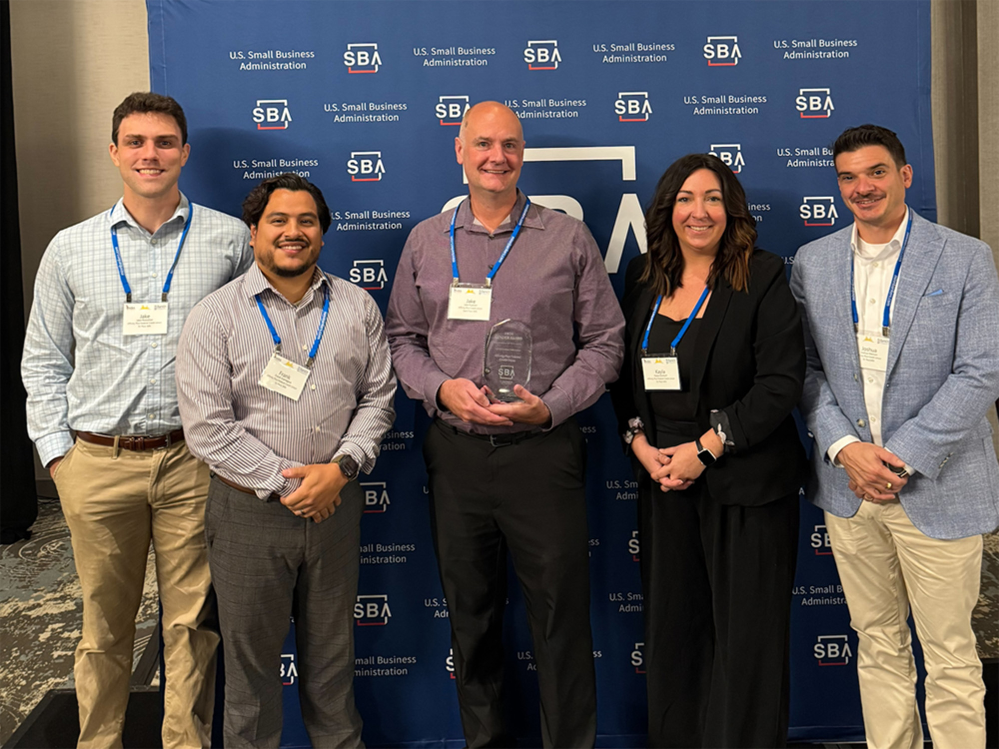 a group of people holding an award trophy