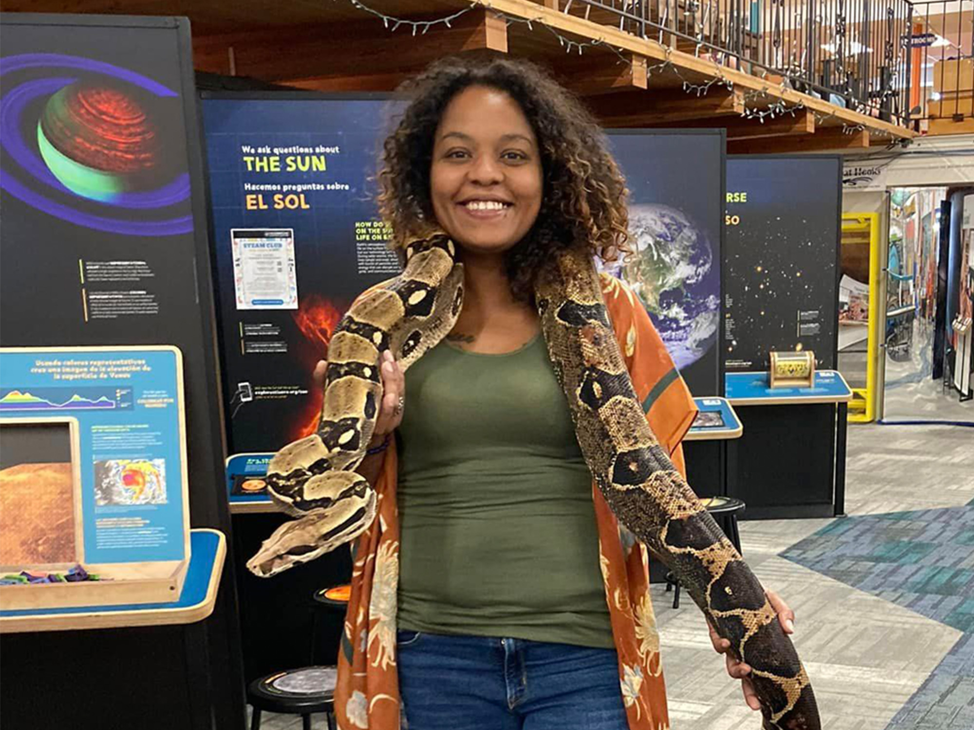 A woman holding a snake in an exhibit hall