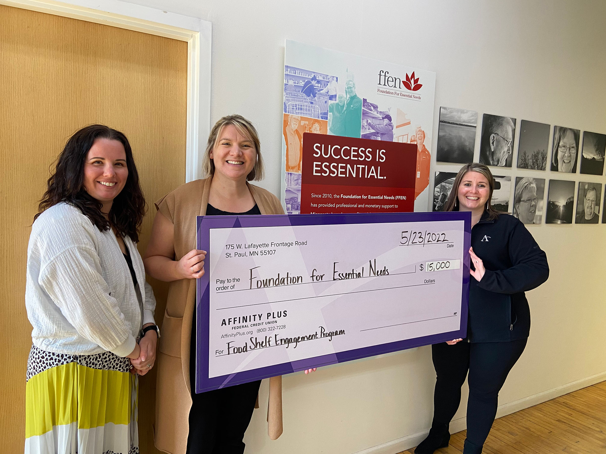 3 women holding a check for $15,000