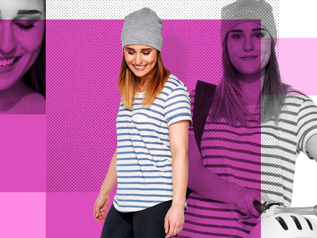 Smiling young woman wearing a striped T-shirt and gray beanie, on a pink background