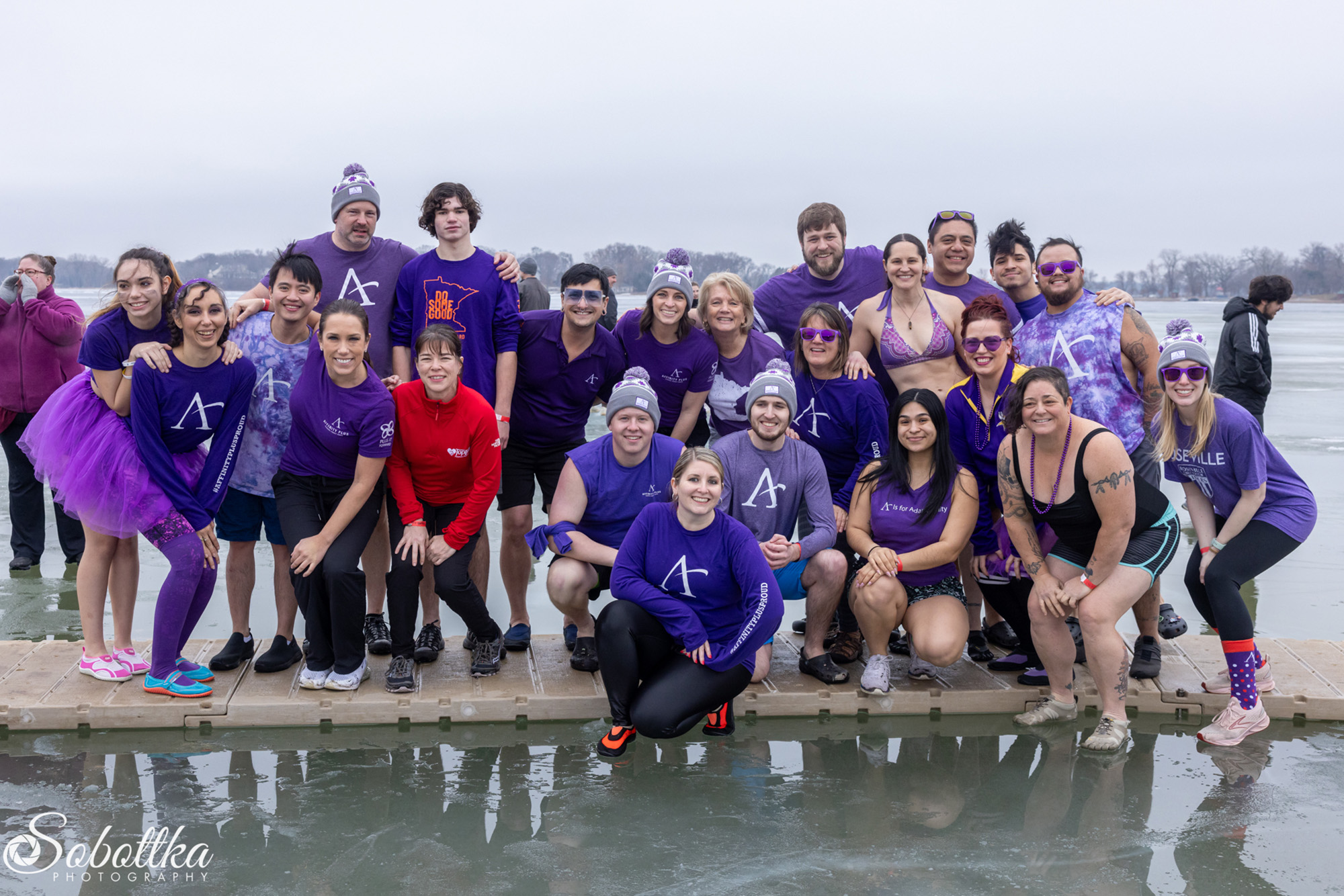 A group of Affinity Plus employees posed around a frozen lake