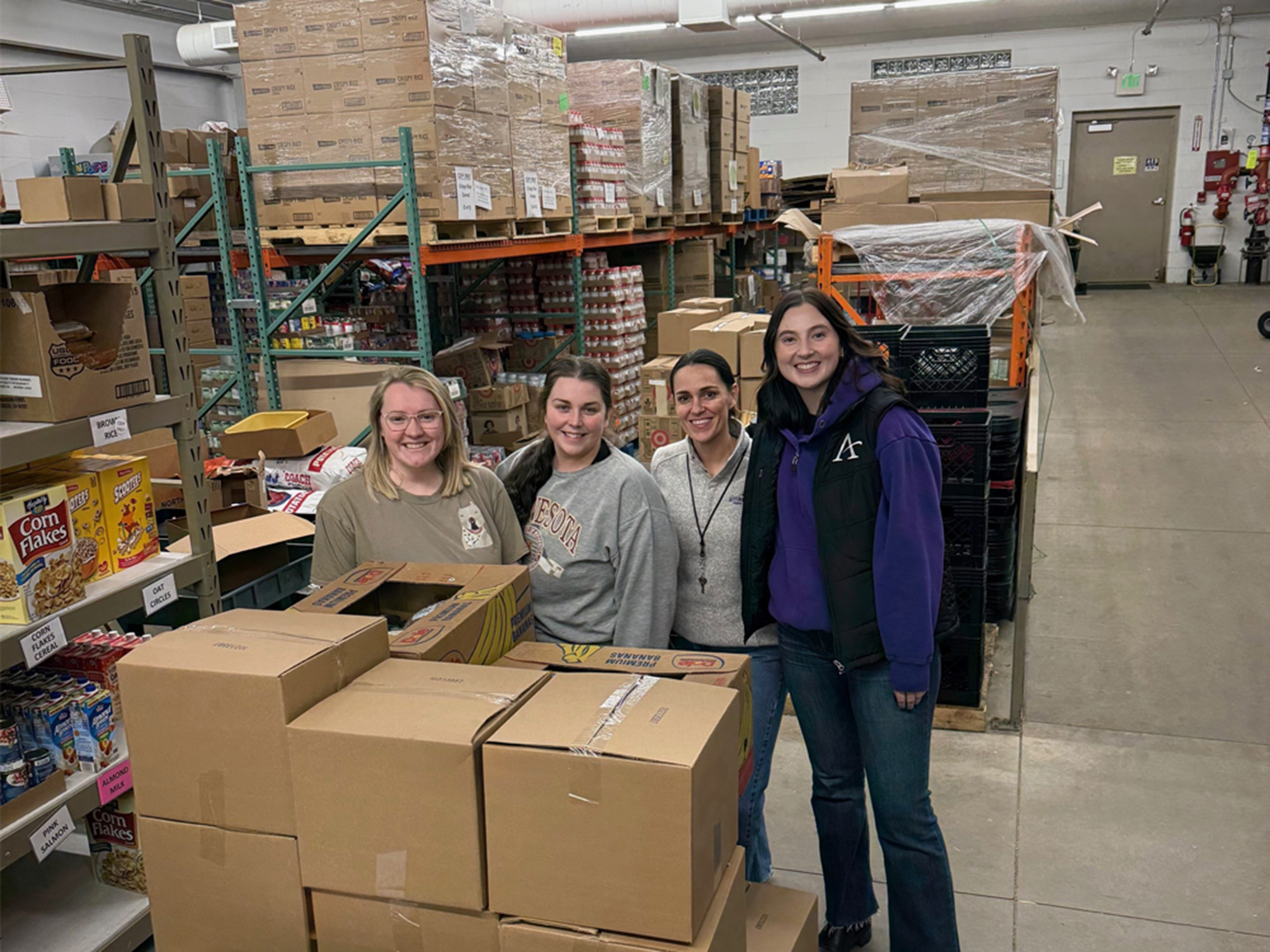 a group of people standing behind boxes in a warehouse