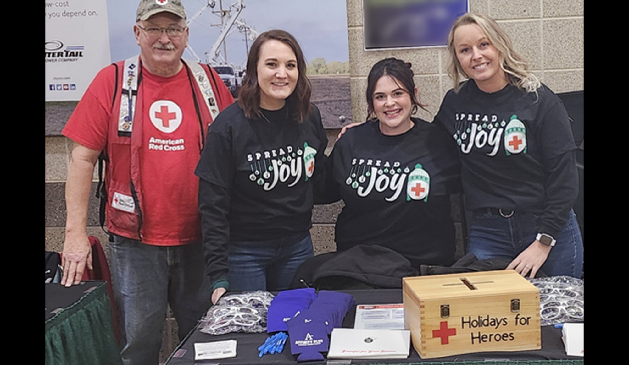 Four people standing behind  an event table