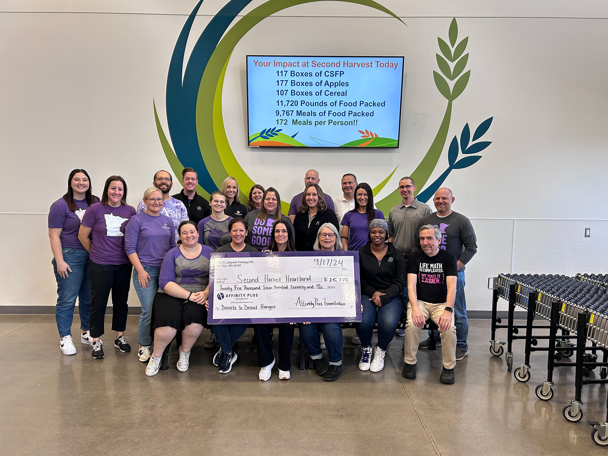 a group of people holding a check for $25,770