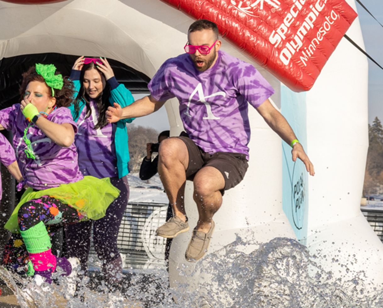 Three people jumping in a frozen lake