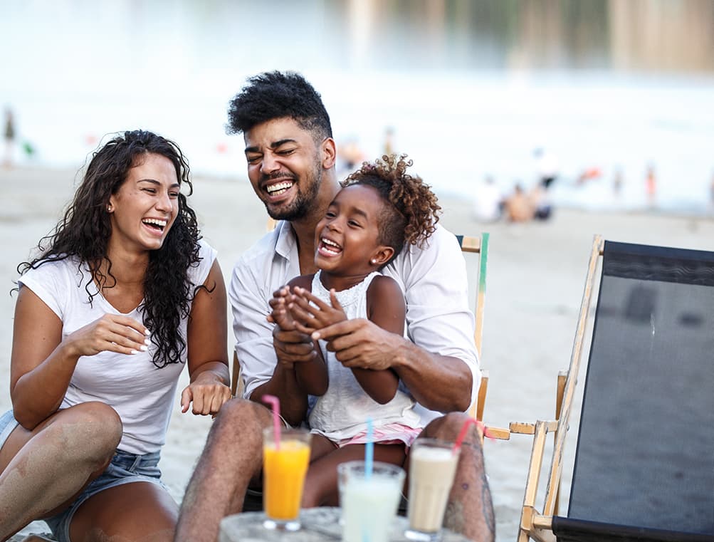 Young Family with child laughing at the beach