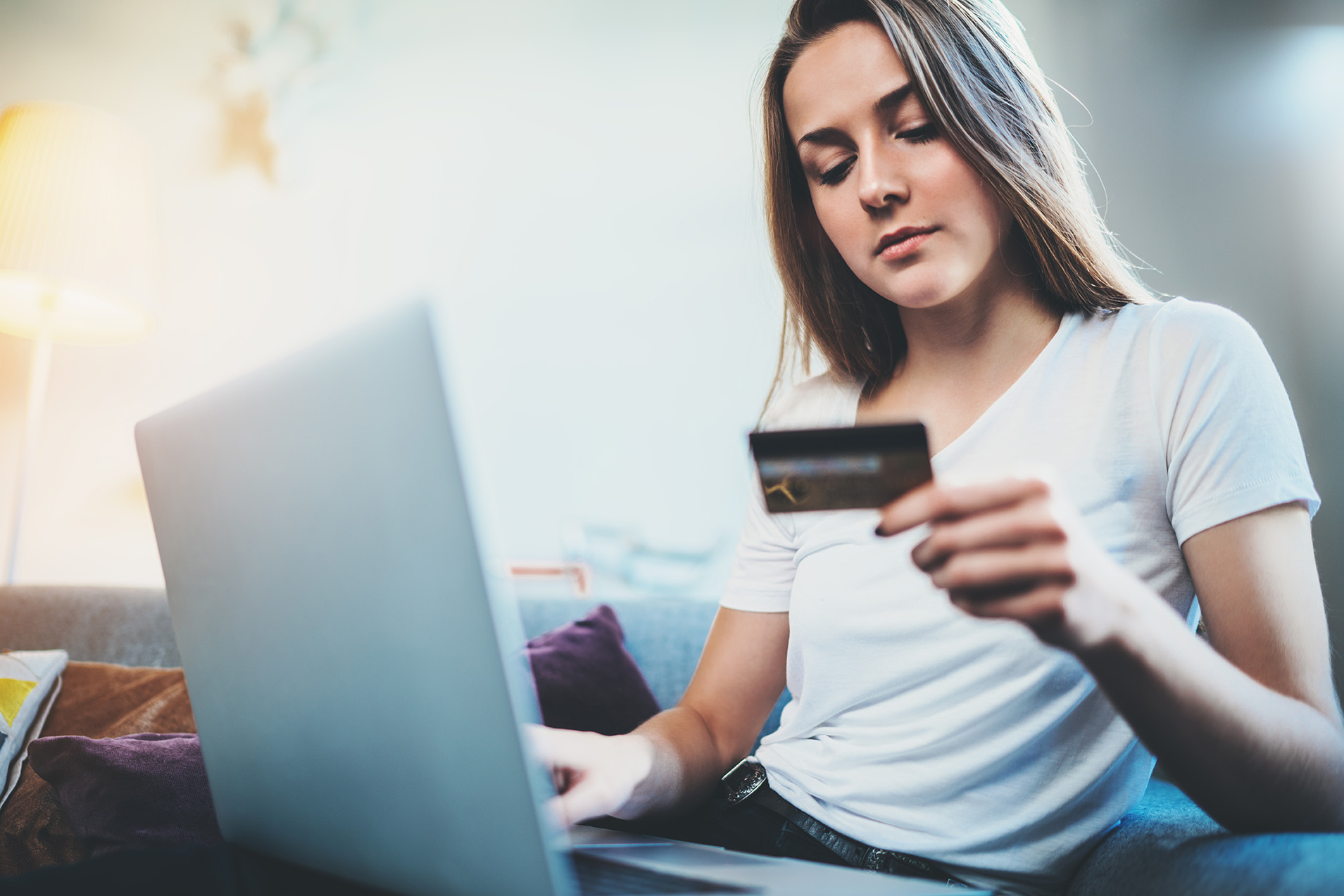 Woman on a laptop with a debit card