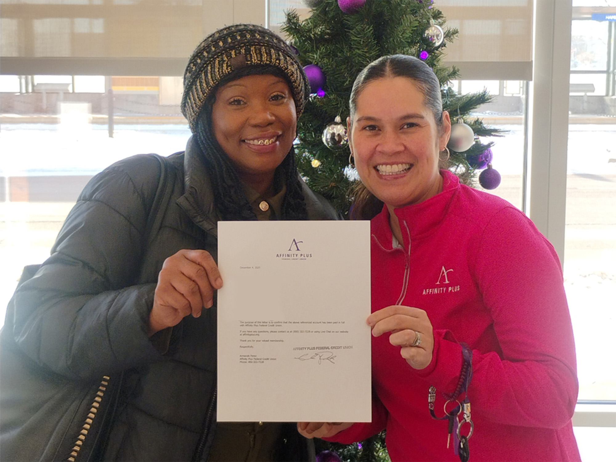 Two women holding letter for paying off mortgage