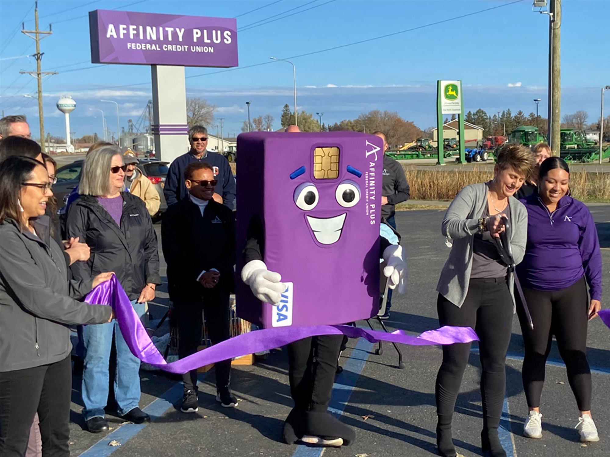 Affinity Plus mascot, Chip, and others cut a purple ribbon