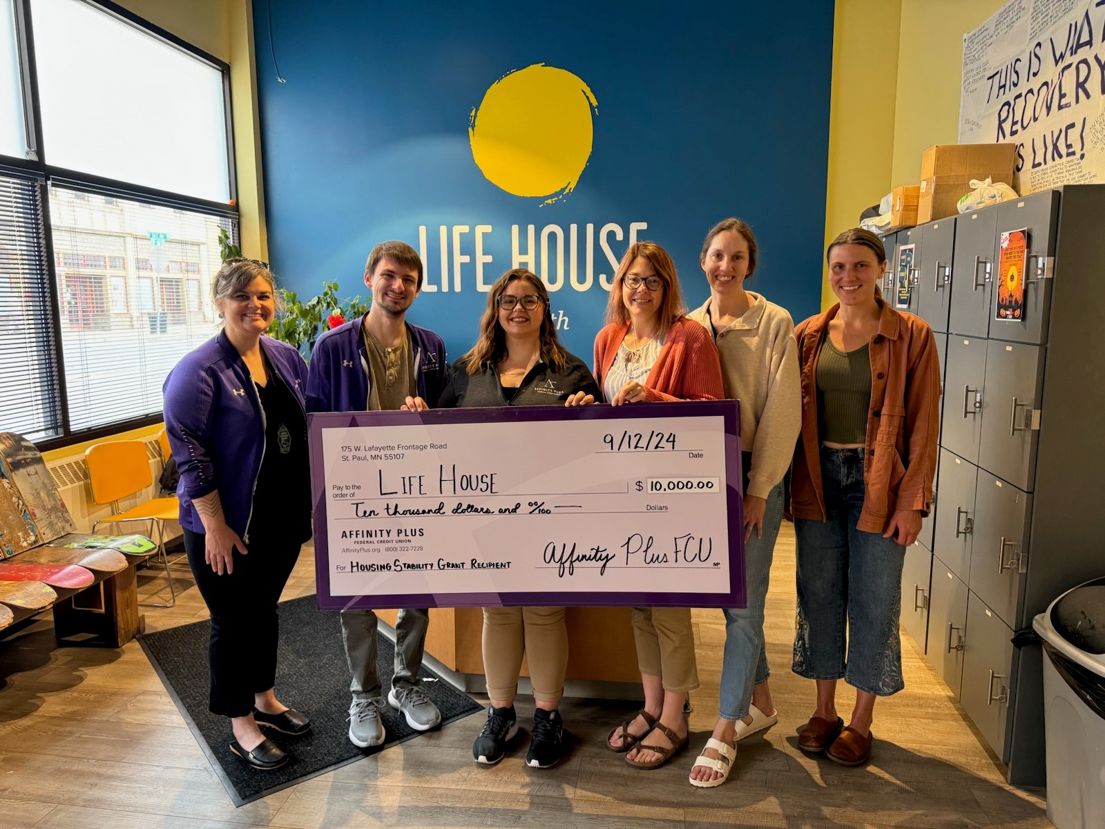 A group of people hodling a 10,000 check to Life House