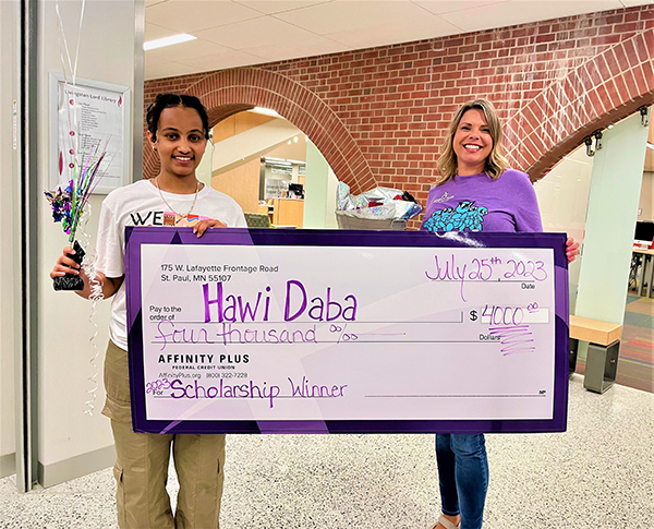scholarship winner and Affinity Plus employee holding check