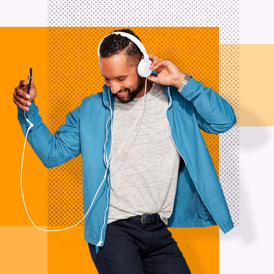 Henry, an Affinity Plus member, listening to headphones dancing, on an orange background